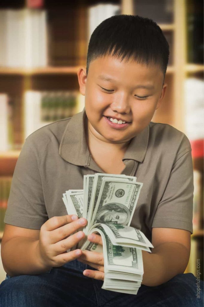 Asian boy with us dollars banknotes