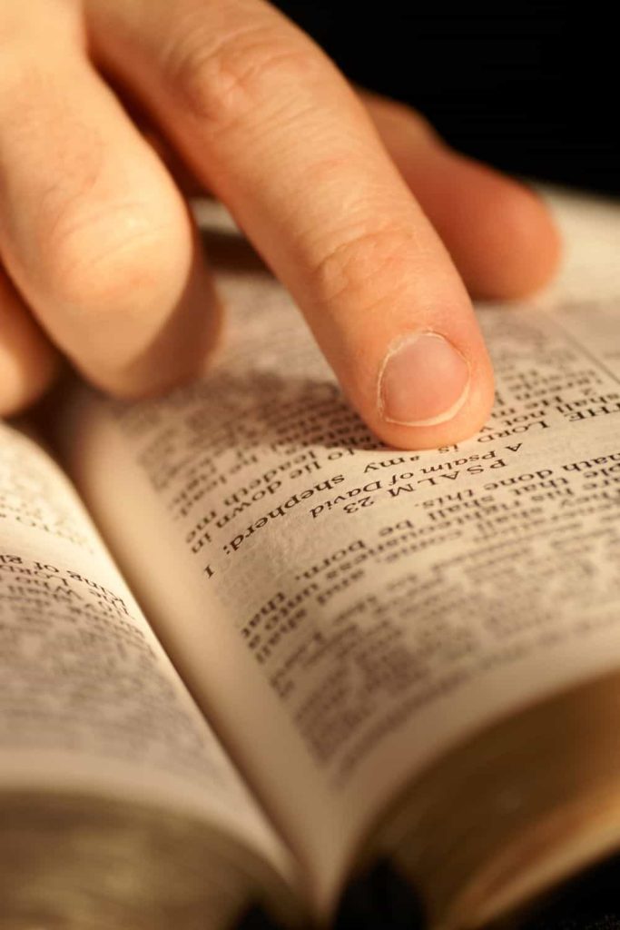 Close-up of Bible Opened on Psalm 23 and pointing finger