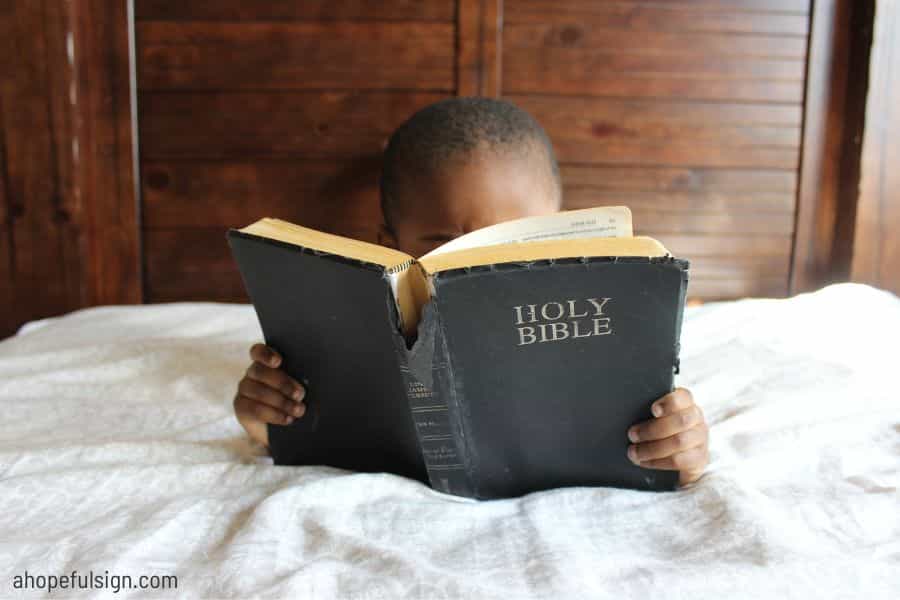 African American young boy reading the Bible