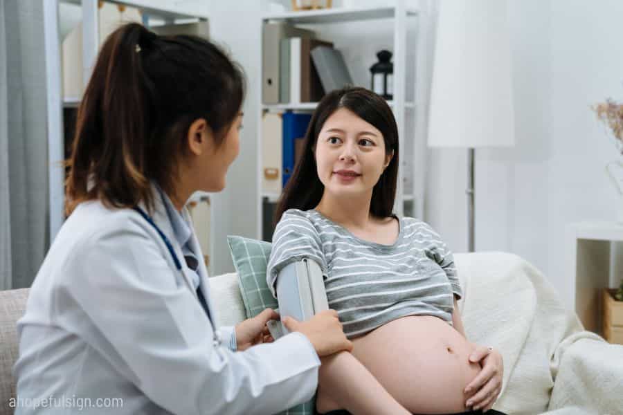 Midwife doing health check of Asian mom
