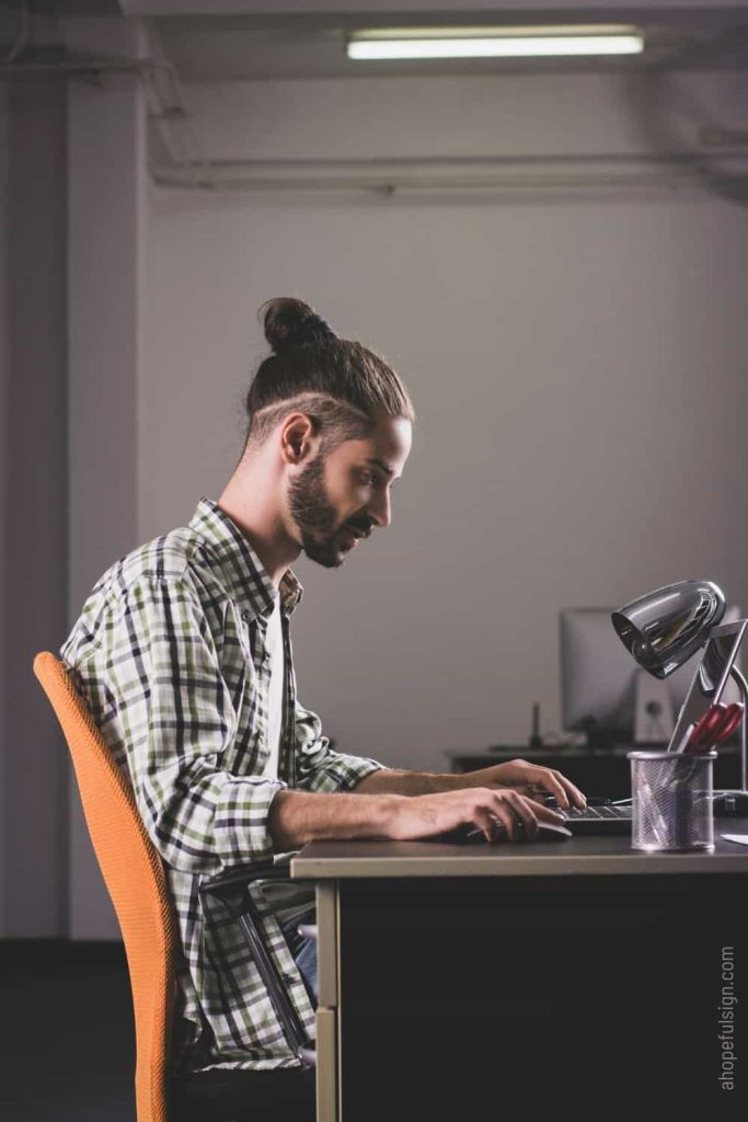 Young man working in office on laptop