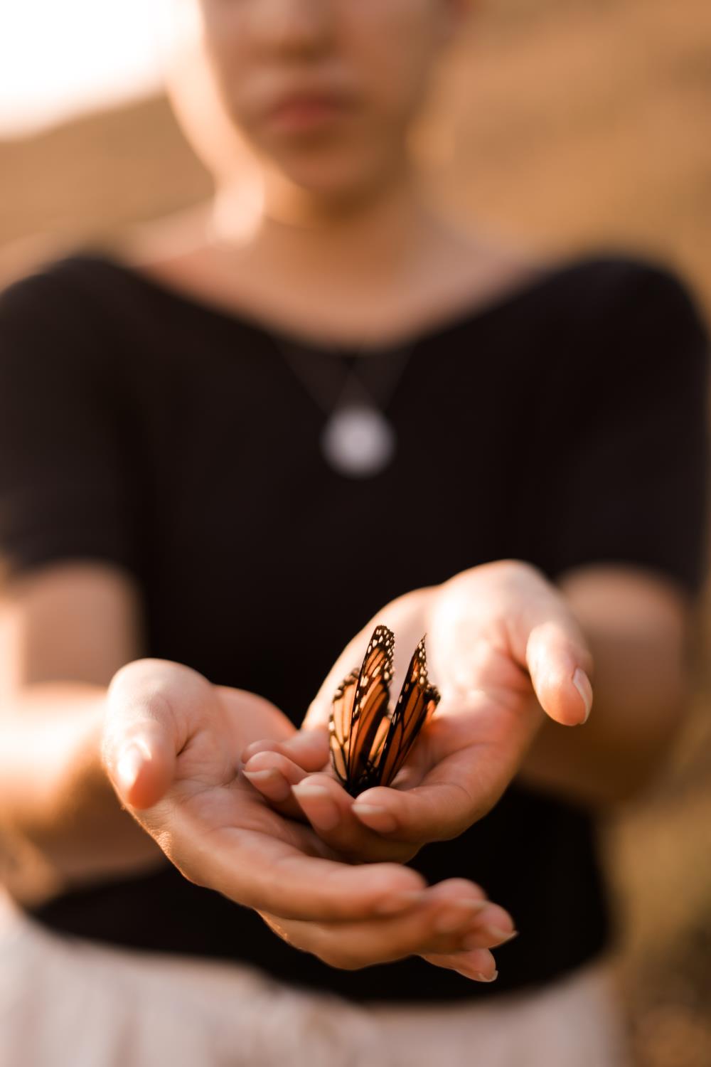 Woman with orange butterfly in her hands