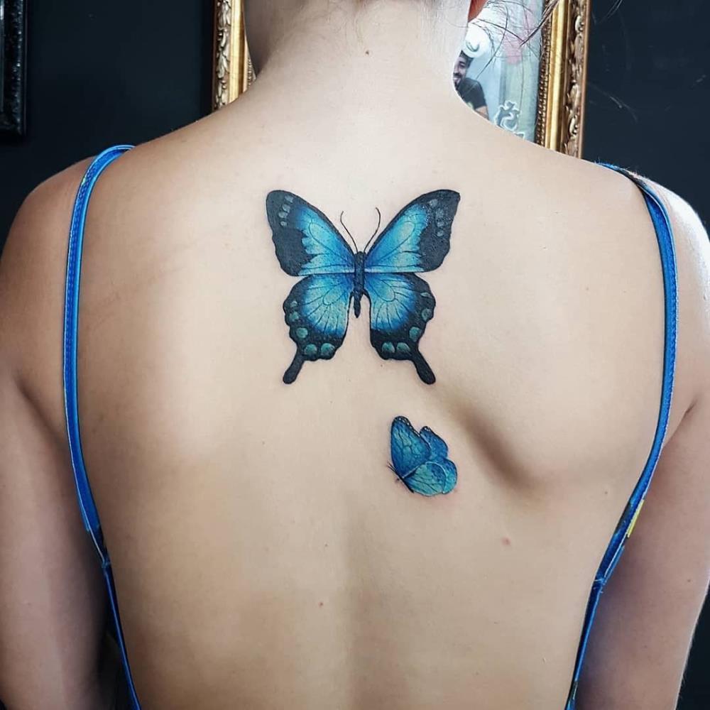 Blue butterfly tattoo on woman's back