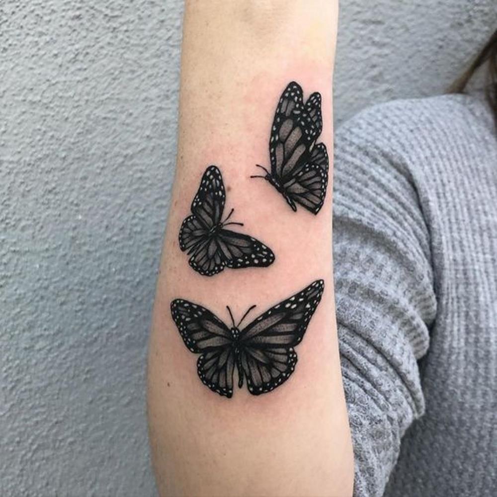Black butterflies tattoo on forearm